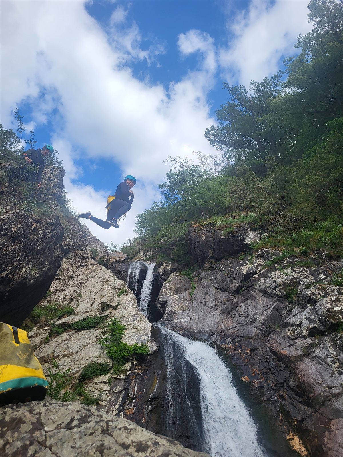 Saut facultatif depuis un rocher au-dessus d'une cascade du canyon du Bramabiau, ciel bleu, Cévennes